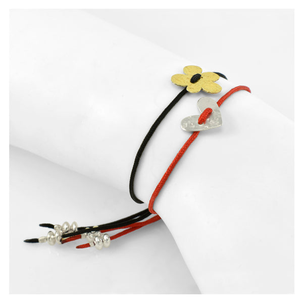 gold flower and silver heart friendship bracelet on black and red cord composition